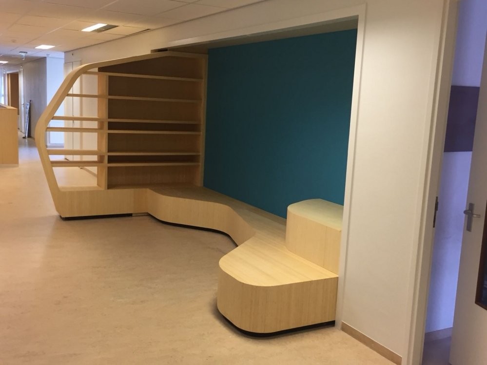 Gebogen maatwerk kast met zitbank in een kinderdagverblijf